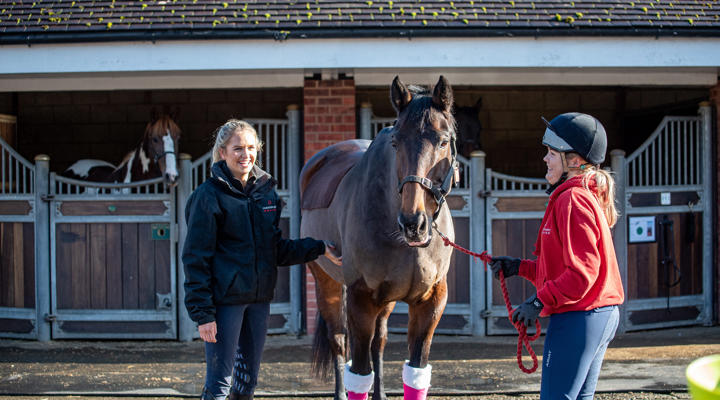 Two students with a horse in the Equine Yard