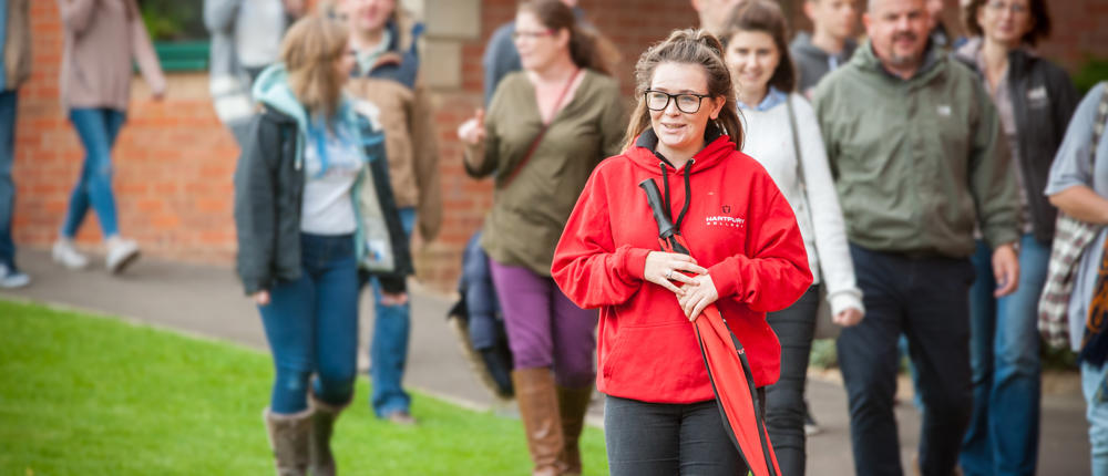 Open Day Guests On Tour With Student Ambassador Holding Umbrella