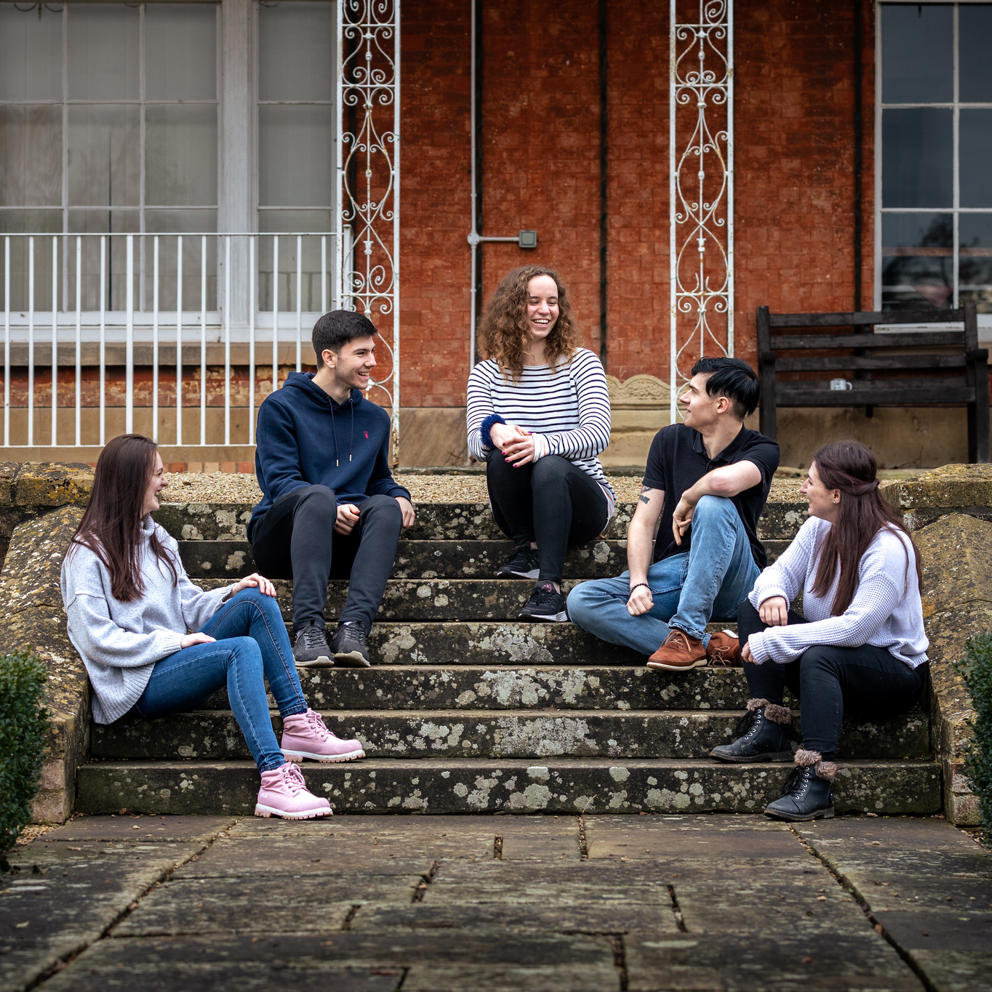 Students Sat On Steps Outside Hartpury House