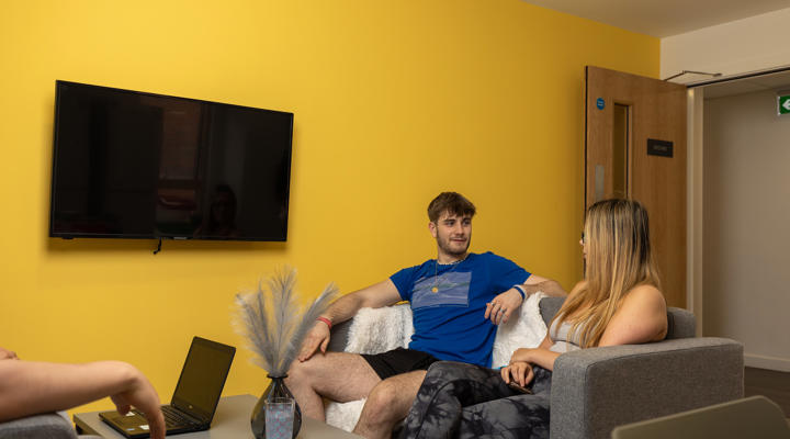 Male and female students sitting on sofa