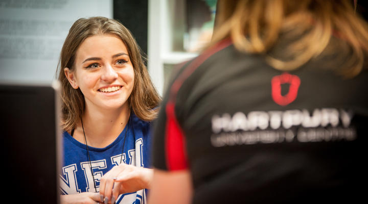 Image of a student smiling at a member of staff sat in front of them
