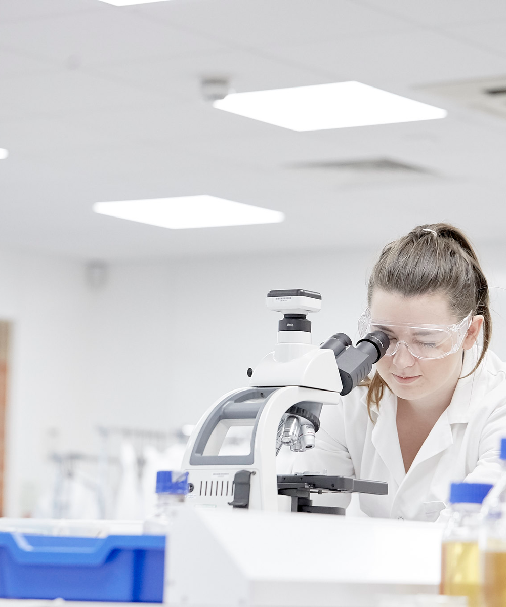 Female Student In Lab Using Microscope