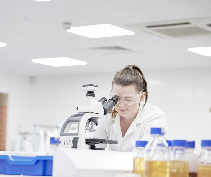Female Student In Lab Using Microscope