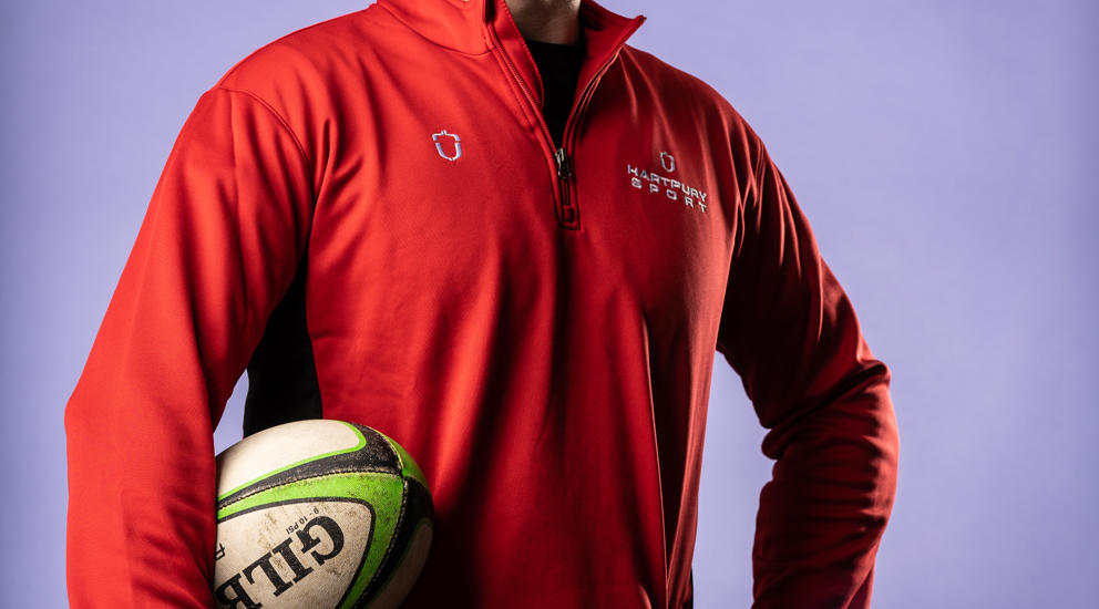 Image of international student posing with a rugby ball under their arm