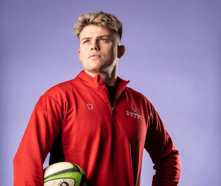 Image of international student posing with a rugby ball under their arm