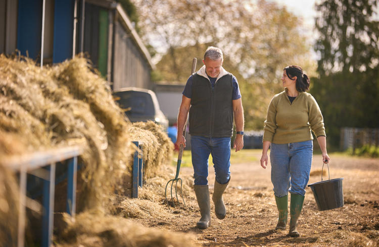 Man And Woman Walking In Cow Shed