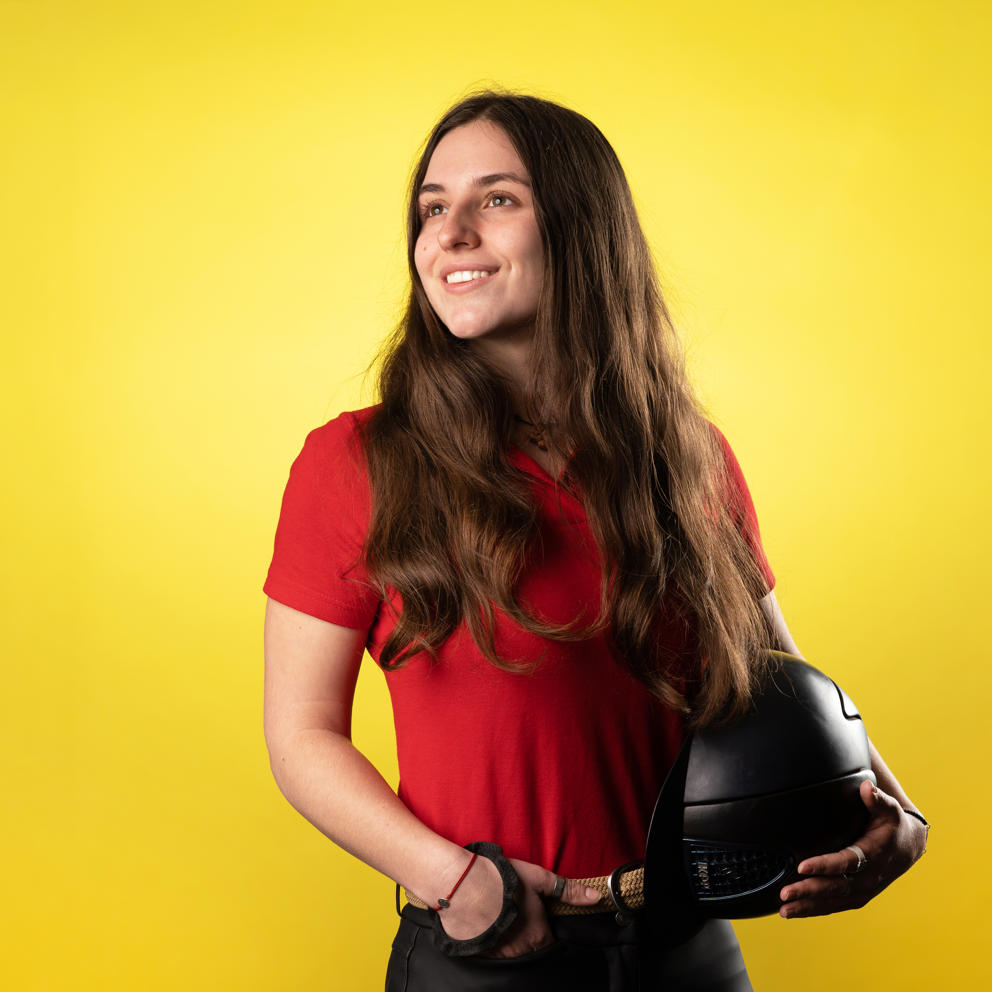 Image of international student at Hartpury holding helmet and smiling for a candid photograph
