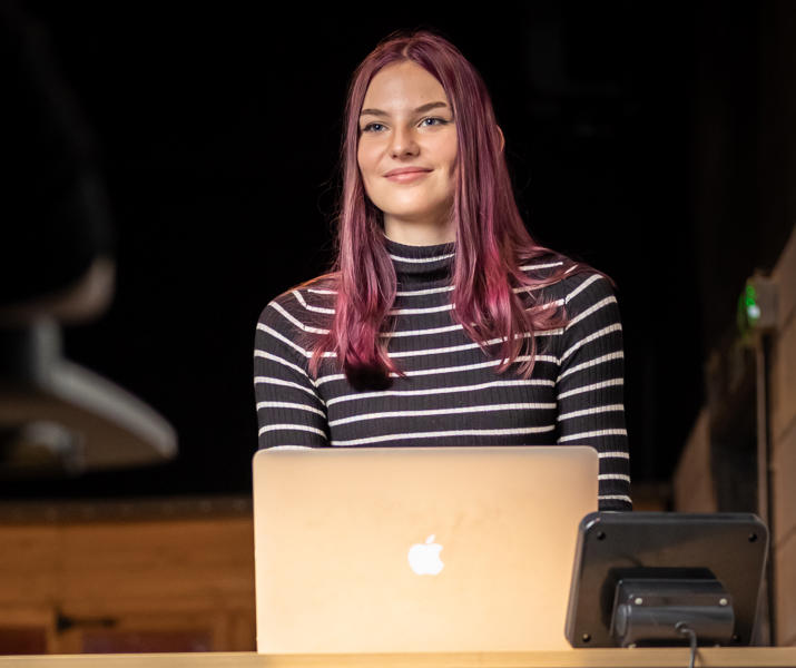 Image of student at a standing desk on their laptop whilst walking on a walking pad